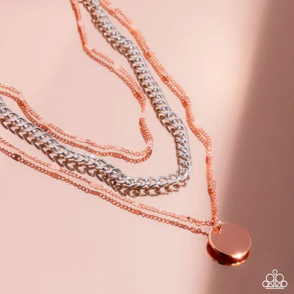 Two copper necklaces with a round pendant on a pink background