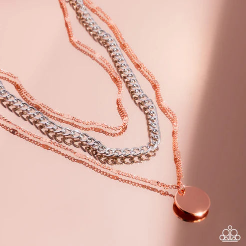 Two copper necklaces with a round pendant on a pink background