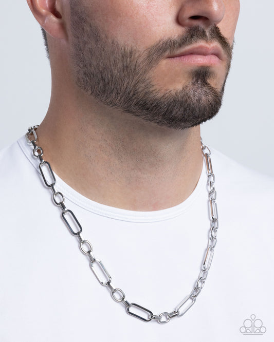 Man wearing a silver chain necklace on a white background