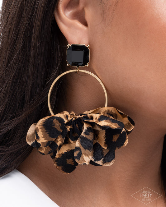 Leopard print hoop earring with a black gemstone on a model.