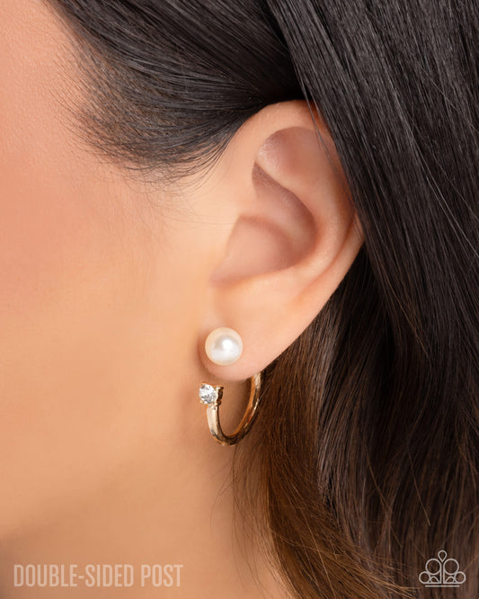Pearl earring worn on an ear with a blurred background