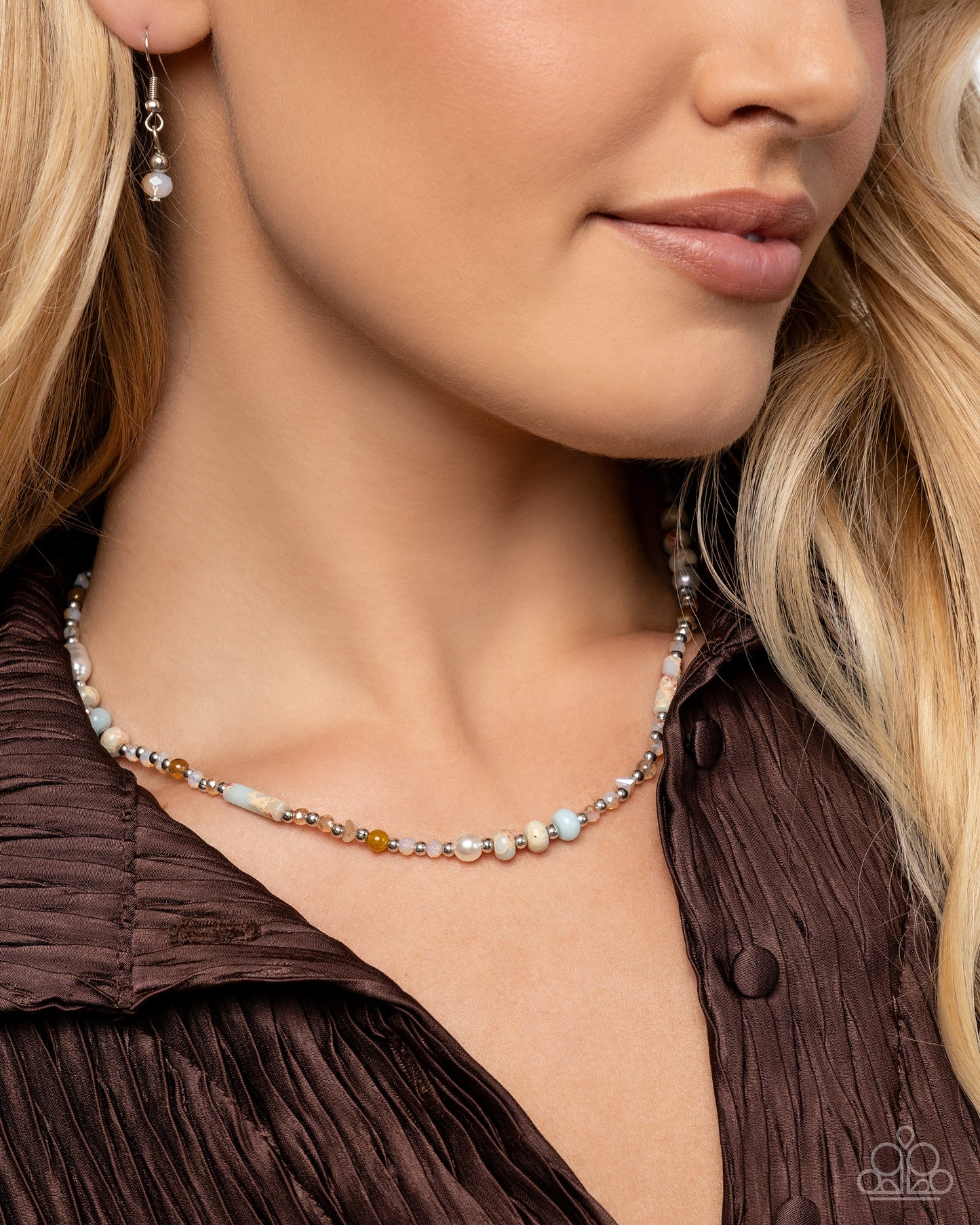 Close-up of a woman wearing a beaded necklace and earrings.