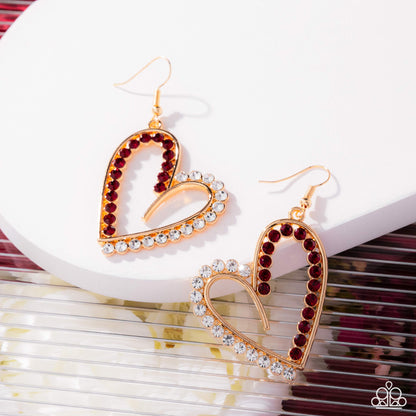Heart-shaped earrings with red and clear gemstones on a white surface