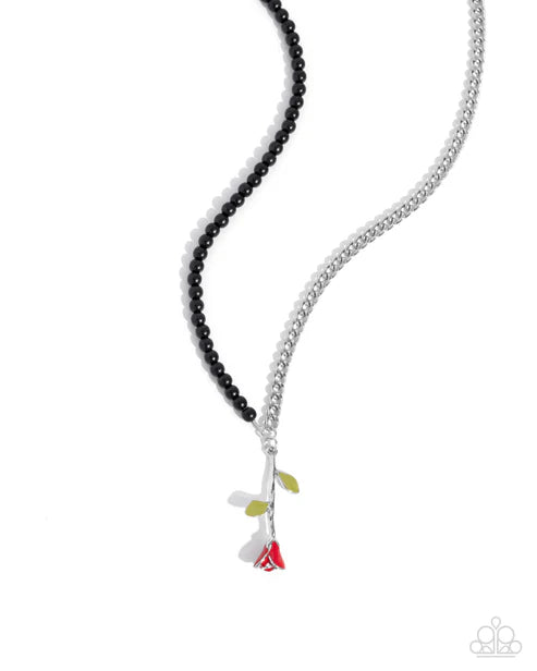 Necklace with black beads and colorful pendant on a white background