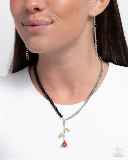 Necklace with colorful pendants worn by a model on a white background