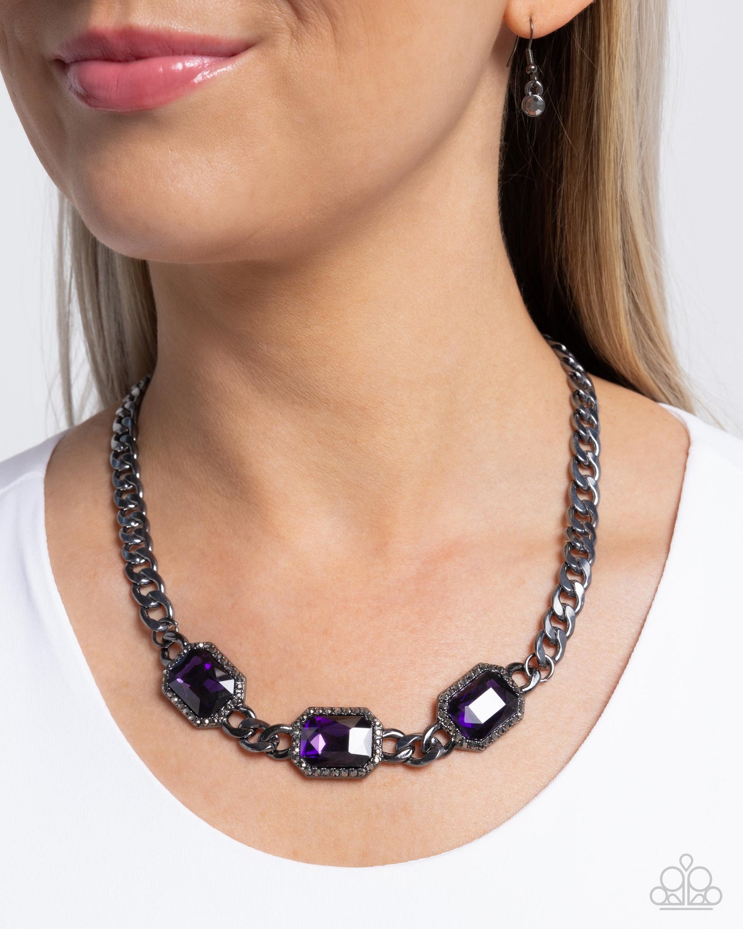 Necklace with purple gemstones worn by a model on a white background