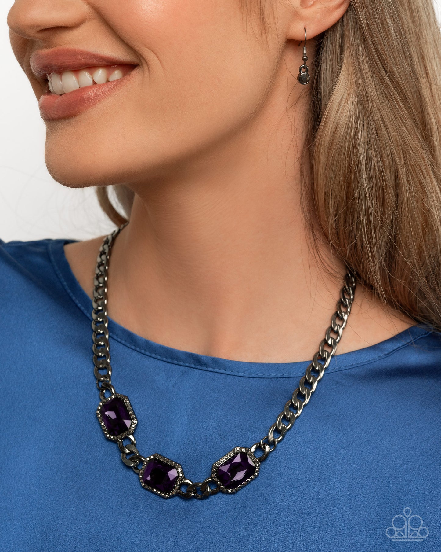 Woman wearing a black chain necklace with purple stones on a white background