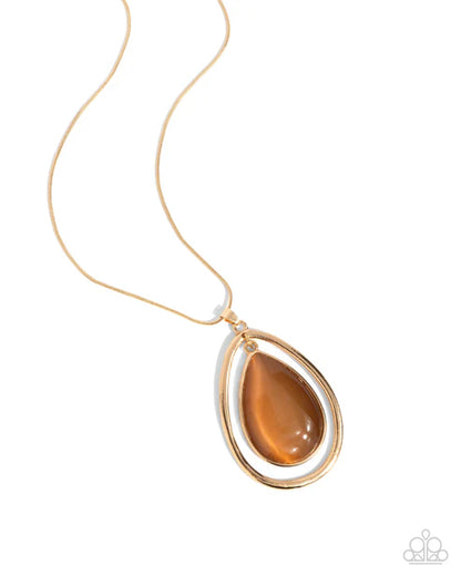 Gold necklace with a teardrop-shaped amber pendant on a white background