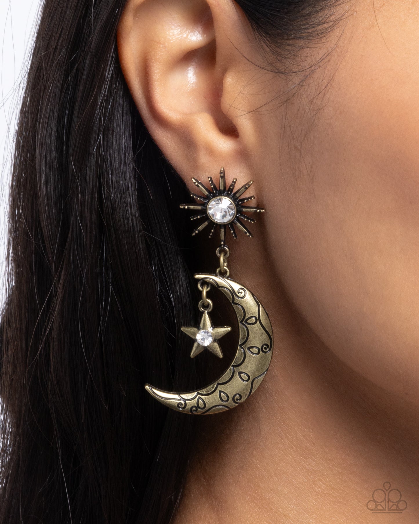 Earring with star and moon design worn on an ear