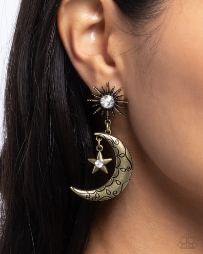 Earring with star and moon design worn on an ear