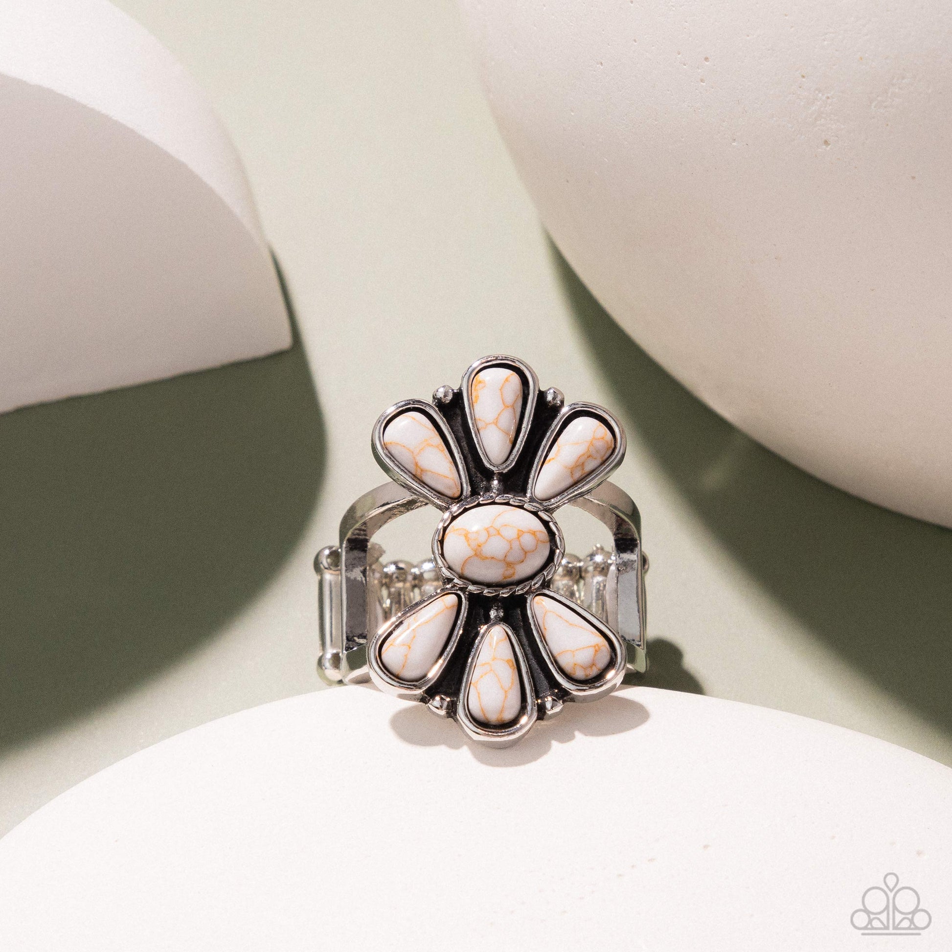 Silver ring with white stones on a light background