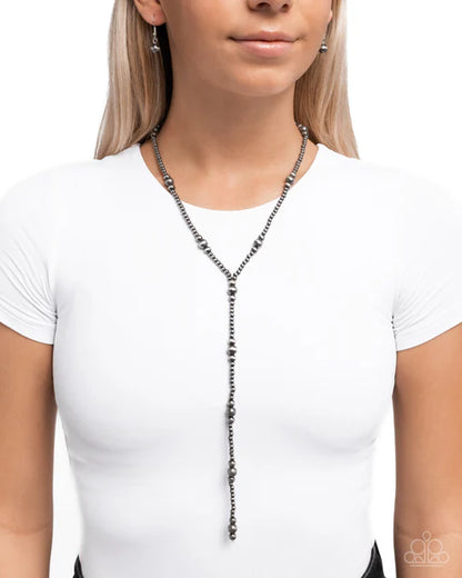 Woman wearing a long necklace against a white background