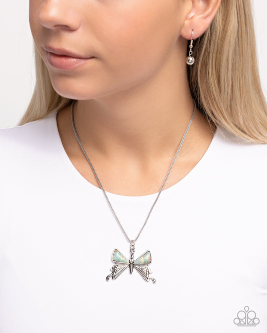 Necklace with a butterfly pendant worn by a person on a white background