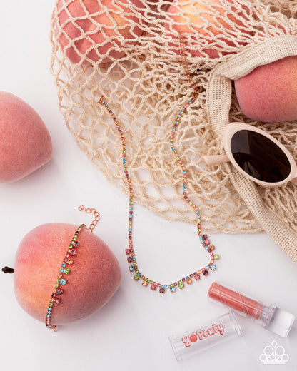 Colorful beaded necklace on a peach with a mesh bag and sunglasses in the background.