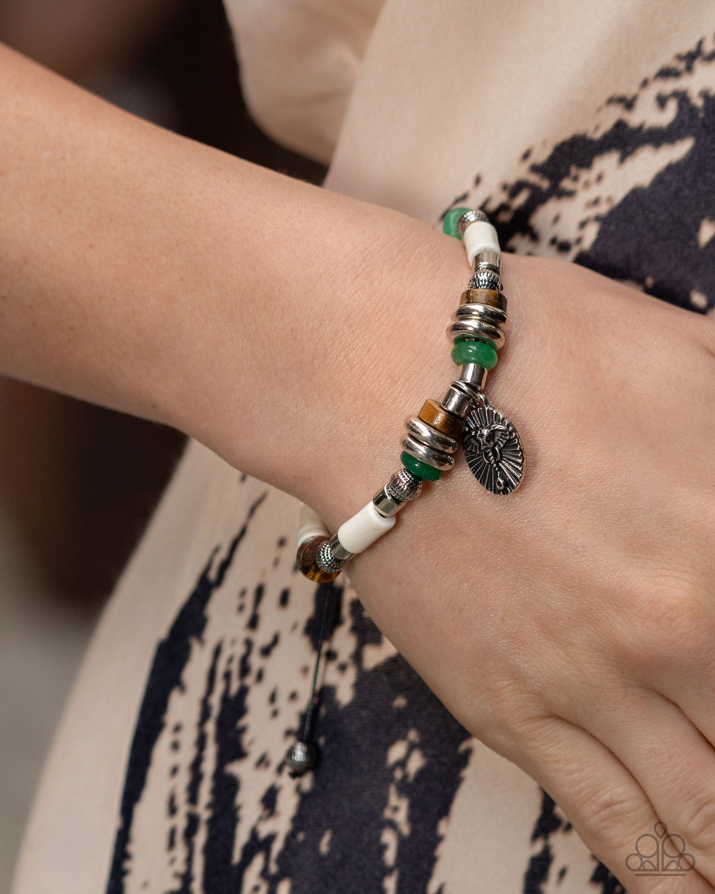 Close-up of a wrist wearing a beaded bracelet with green and white beads.