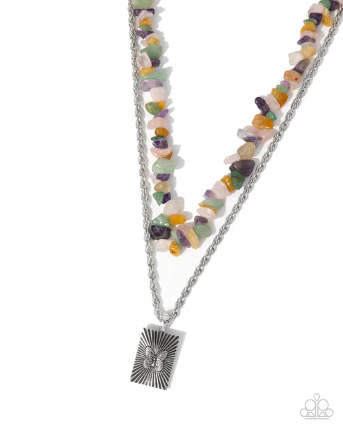 Necklace with multicolored beads and a silver pendant on a white background