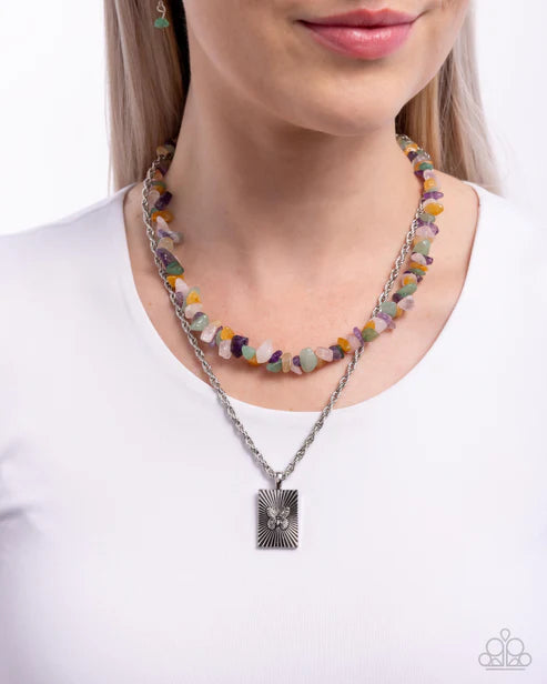 Necklace with colorful beads and a silver pendant on a white background