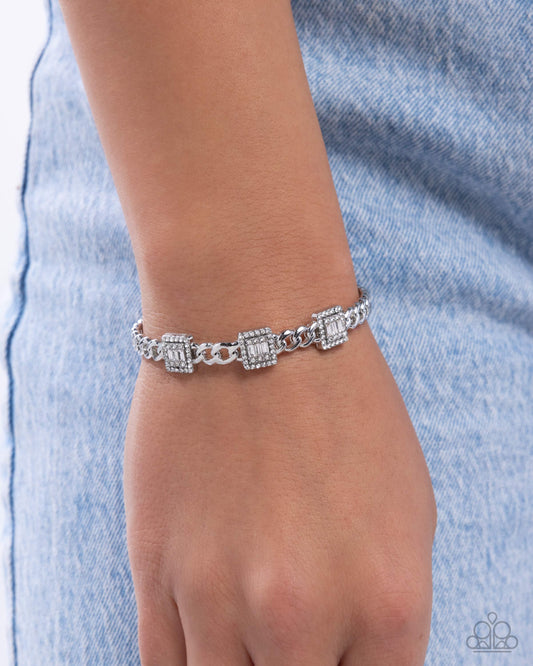 Silver bracelet on a wrist with a denim background