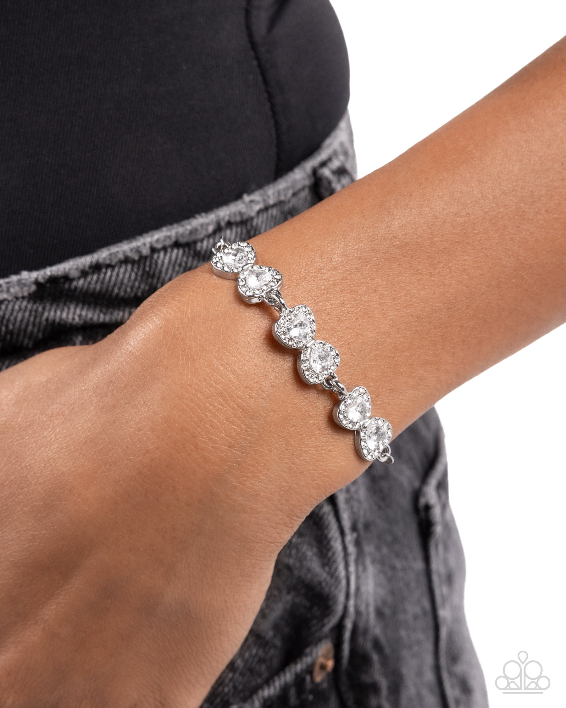Silver bracelet on a wrist with a white background