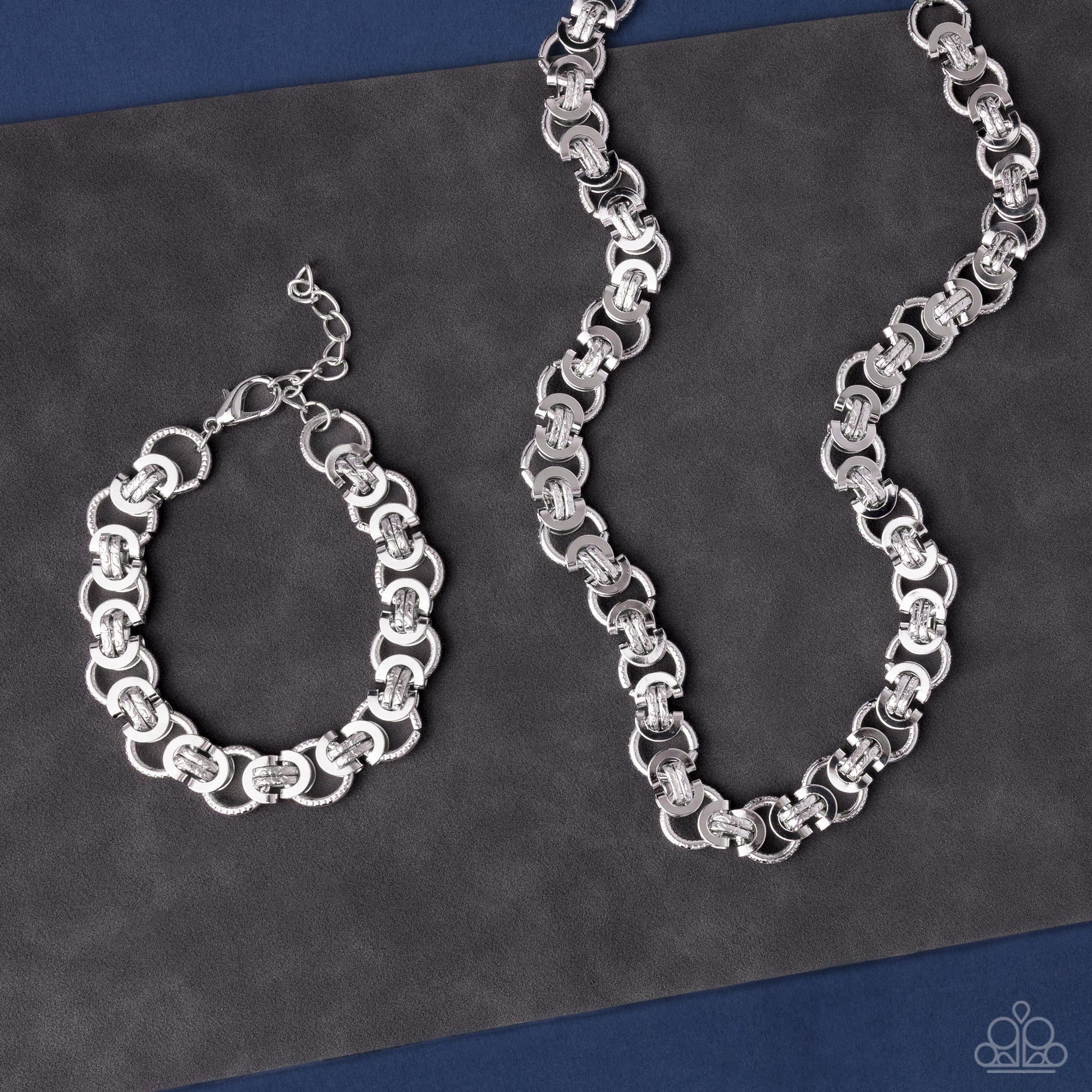 Silver chain necklace and bracelet on a dark gray background