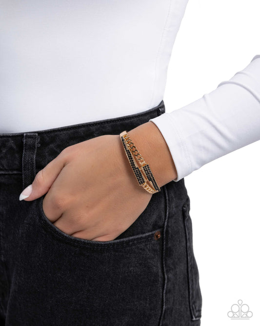 Person wearing a gold bracelet on a white background