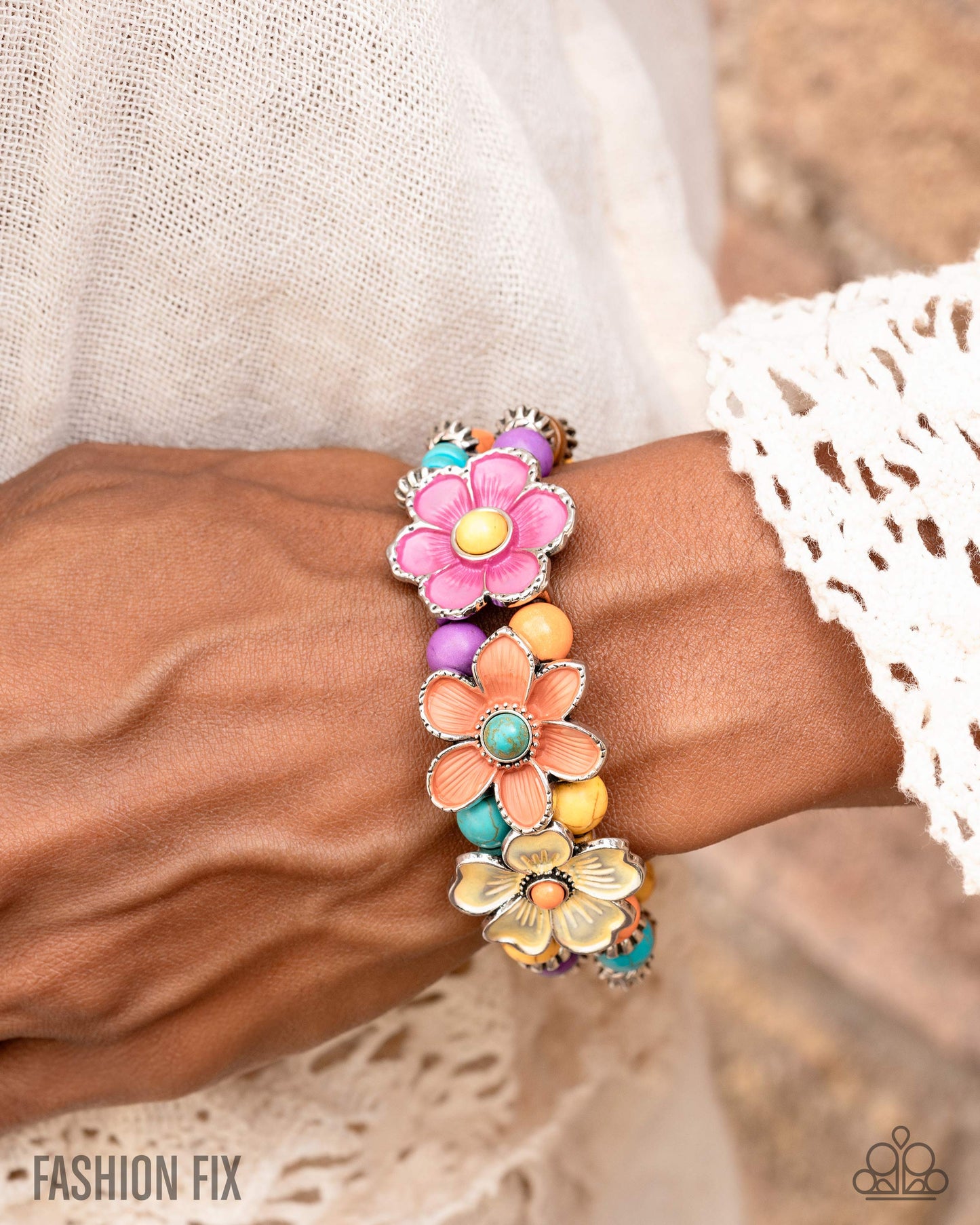 Colorful floral bracelet on a wrist with a blurred background