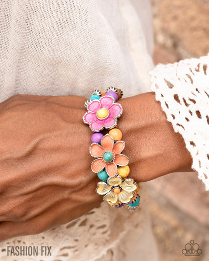 Colorful floral bracelet on a wrist with a blurred background