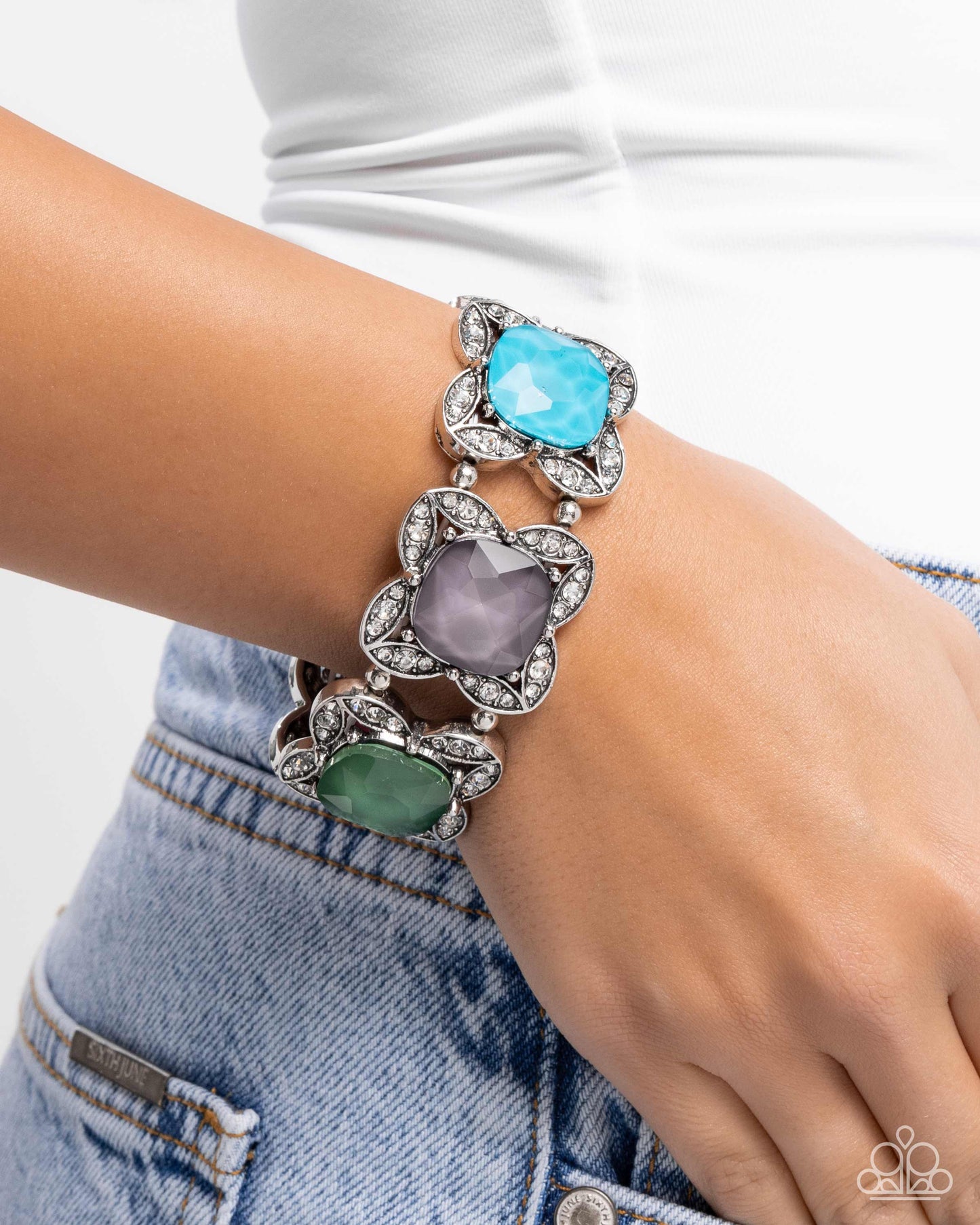 Multicolored gemstone bracelet on a wrist with a white background