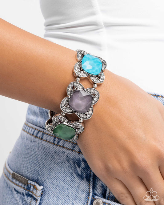 Multicolored gemstone bracelet on a wrist with a white background