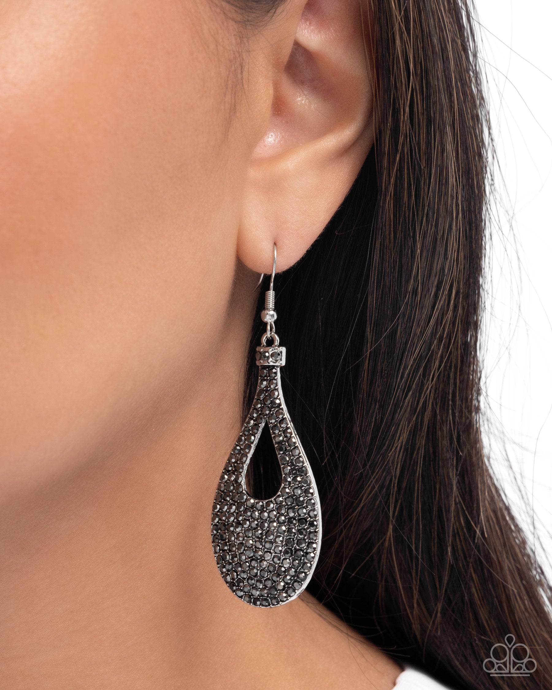 Teardrop-shaped earring worn by a model on a neutral background