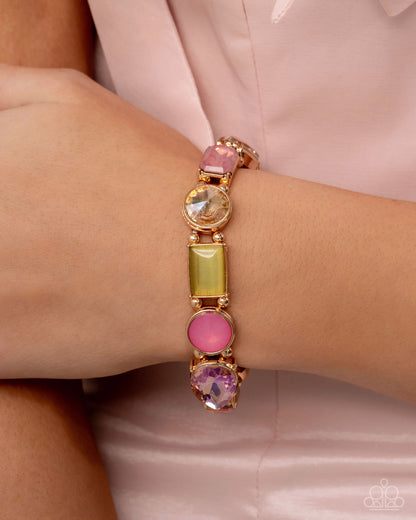 Bracelet with colorful gemstones on a wrist against a light pink background