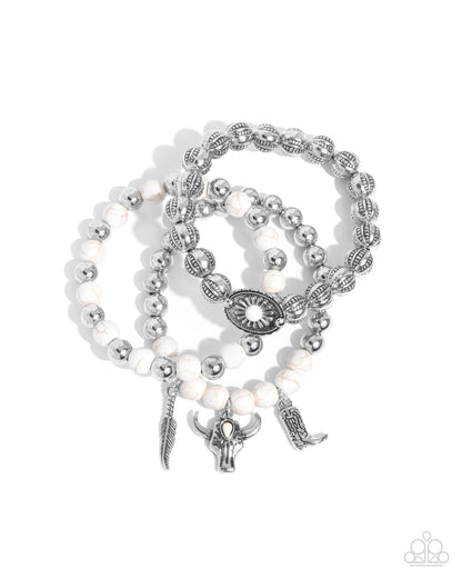 Set of pearl and silver beaded bracelets with charms on a white background