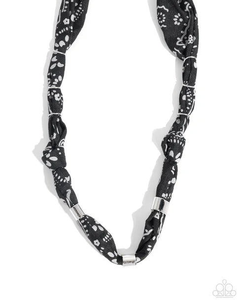 Black and white patterned necklace on a white background