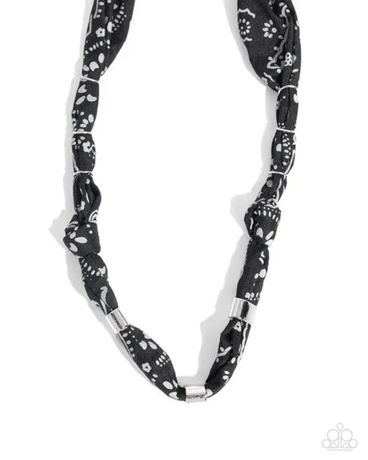 Black and white patterned necklace on a white background