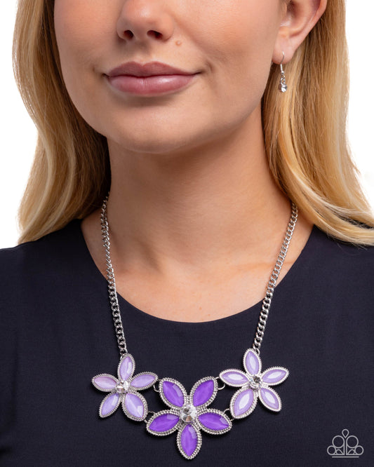 Purple floral necklace worn by a model on a white background