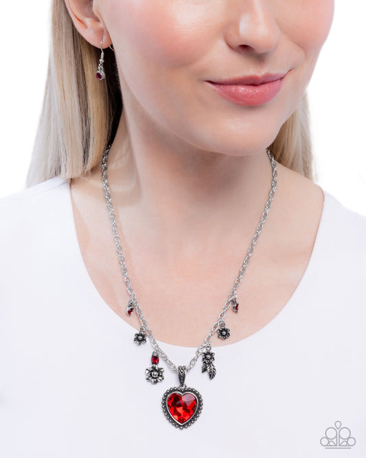 Necklace with a red heart pendant worn by a model on a white background