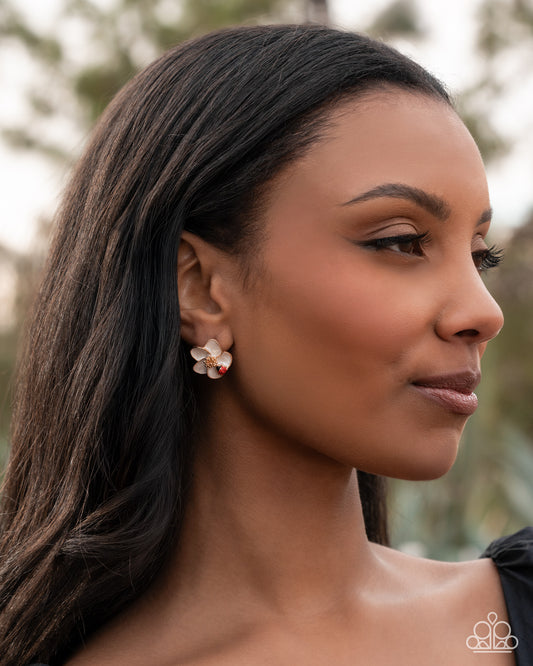 Woman wearing a floral earring with a blurred natural background