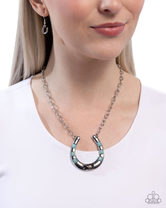 Necklace with a horseshoe design worn by a model on a white background