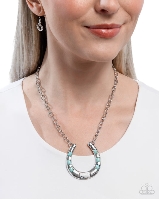 Woman wearing a silver and turquoise horseshoe necklace on a white background