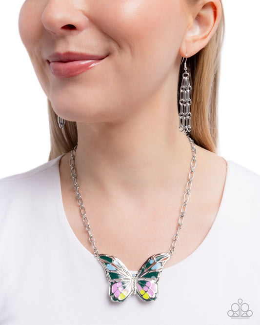 Butterfly necklace and earrings on a model against a white background