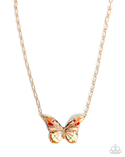 Butterfly-shaped pendant on a gold chain against a white background