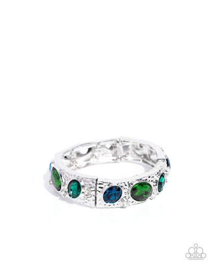 Silver ring with green and blue gemstones on a white background