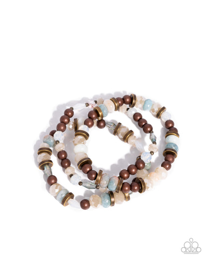 Stack of beaded bracelets with brown, gold, and multicolored beads on a white background