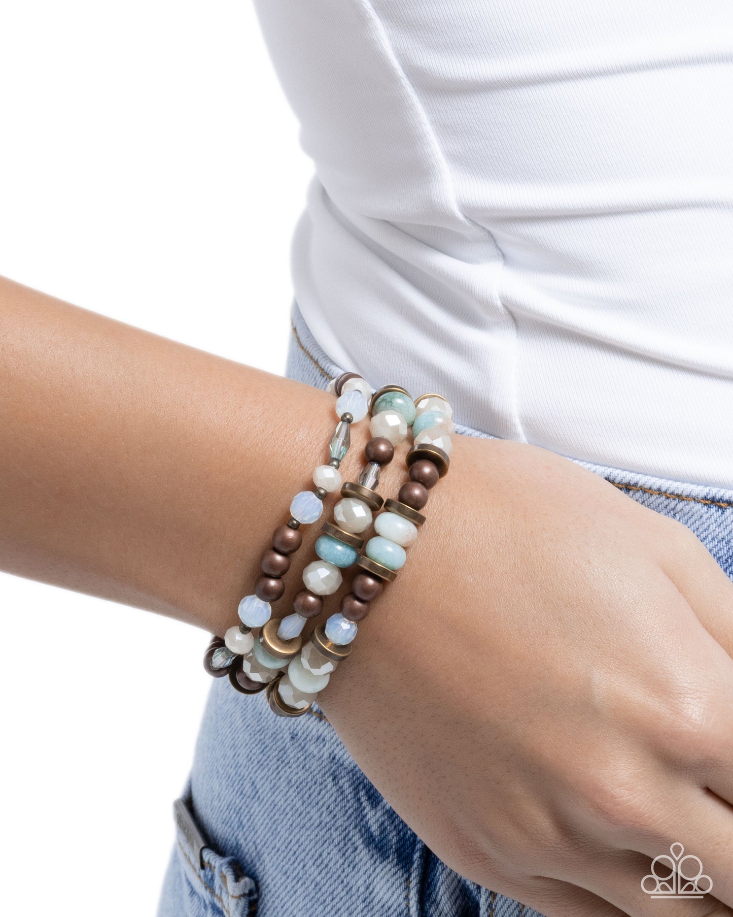 Multistrand beaded bracelet on a wrist with a white shirt and blue jeans background