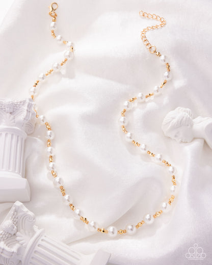 Pearl and gold necklace on a white classical sculpture background