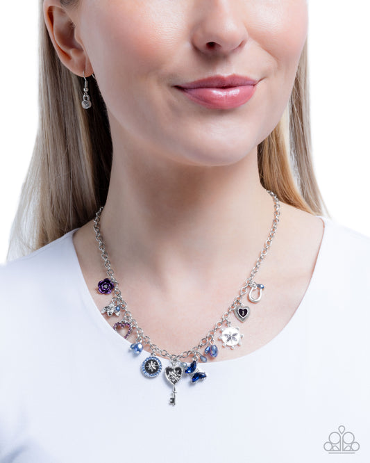 Necklace with various charms worn by a model on a white background