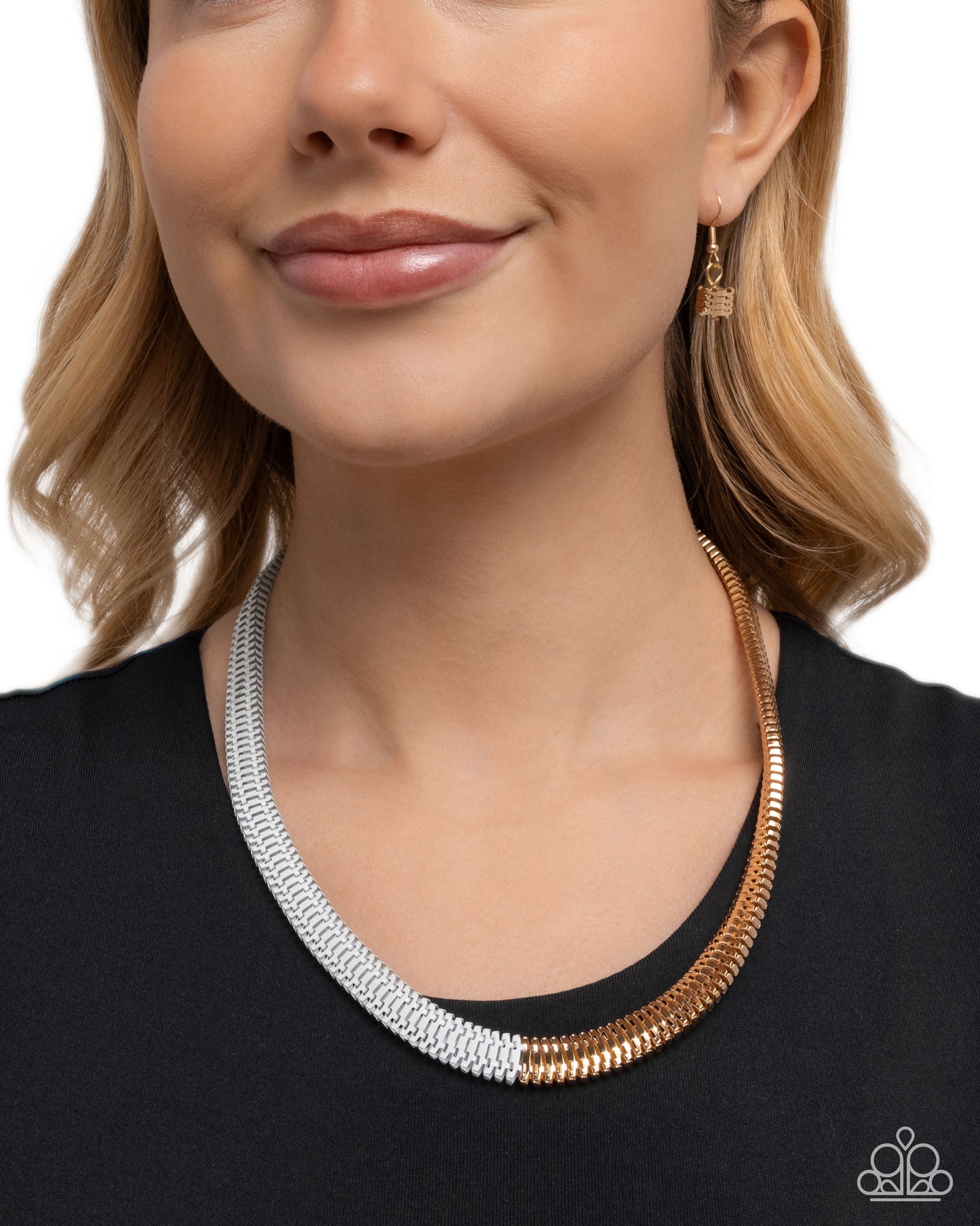 Woman wearing a gold and silver necklace with a plain background
