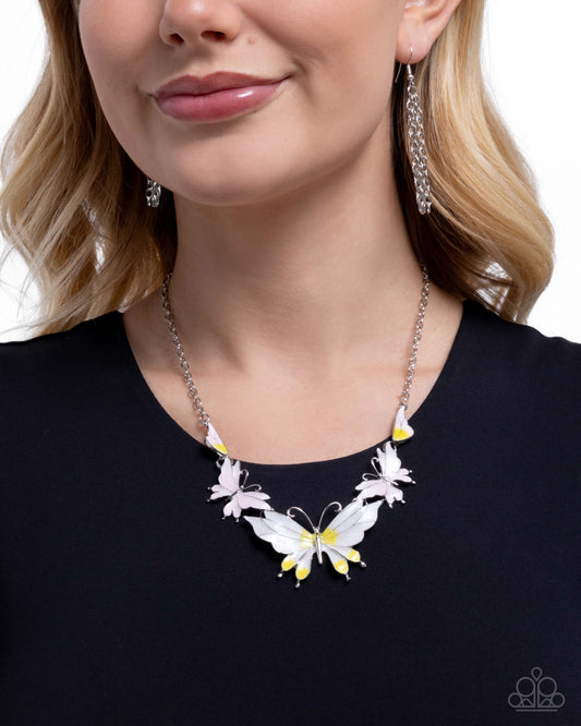 Woman wearing a butterfly-themed necklace and earrings on a white background