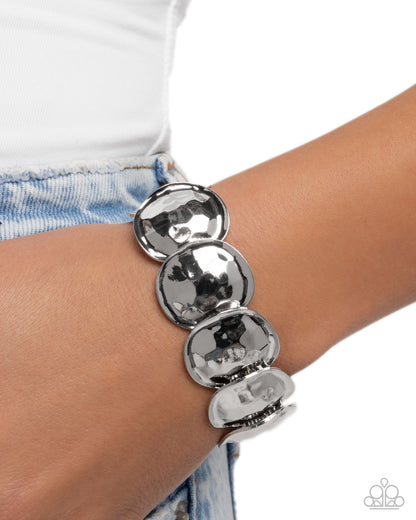 Silver bracelet on a wrist with a white background