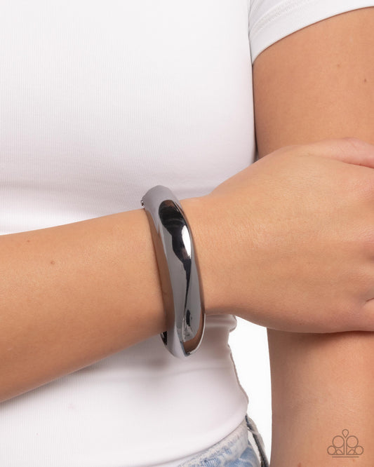 Silver bracelet on a wrist against a white background